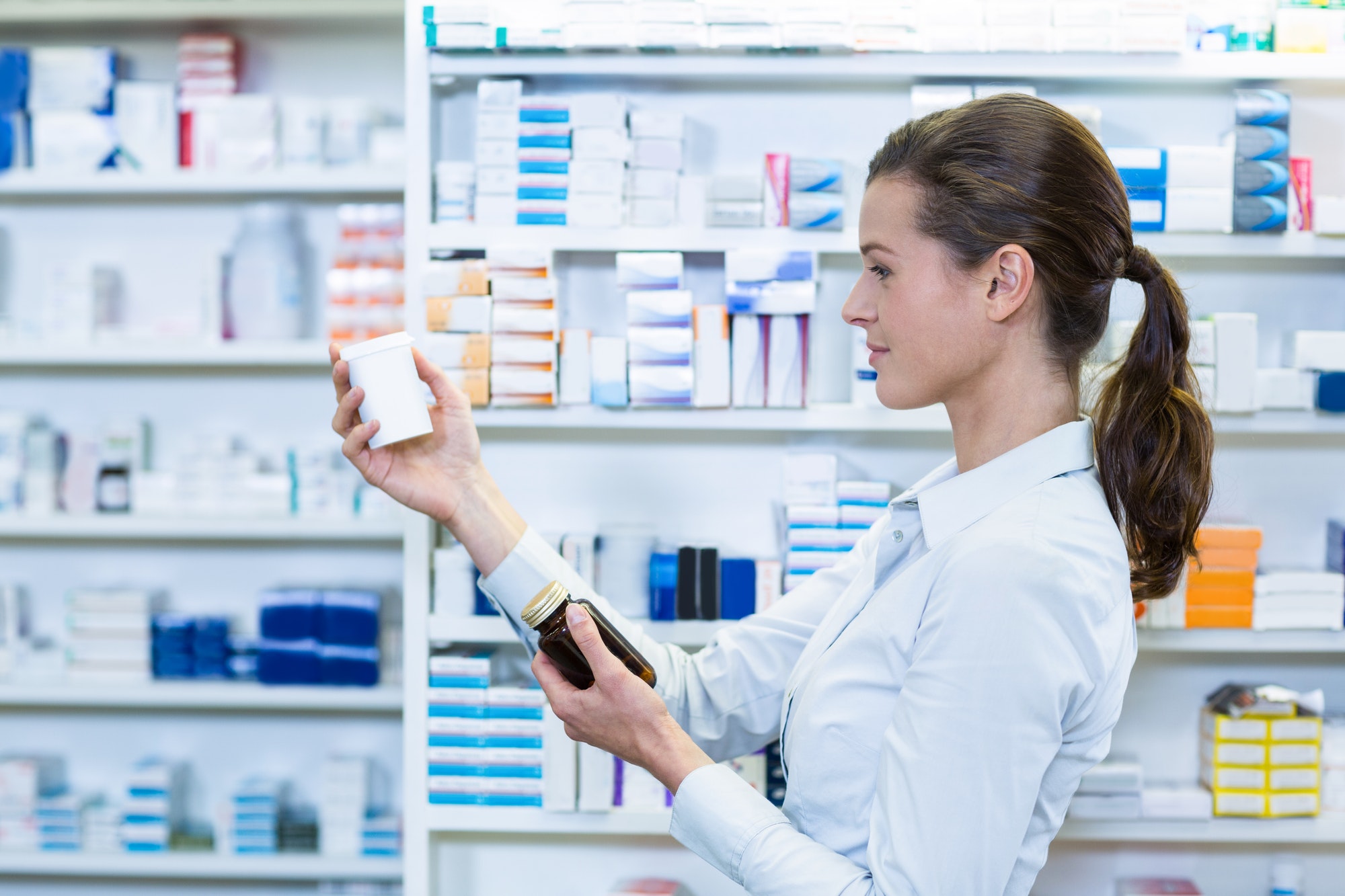 Pharmacist examining medication bottle label for accuracy